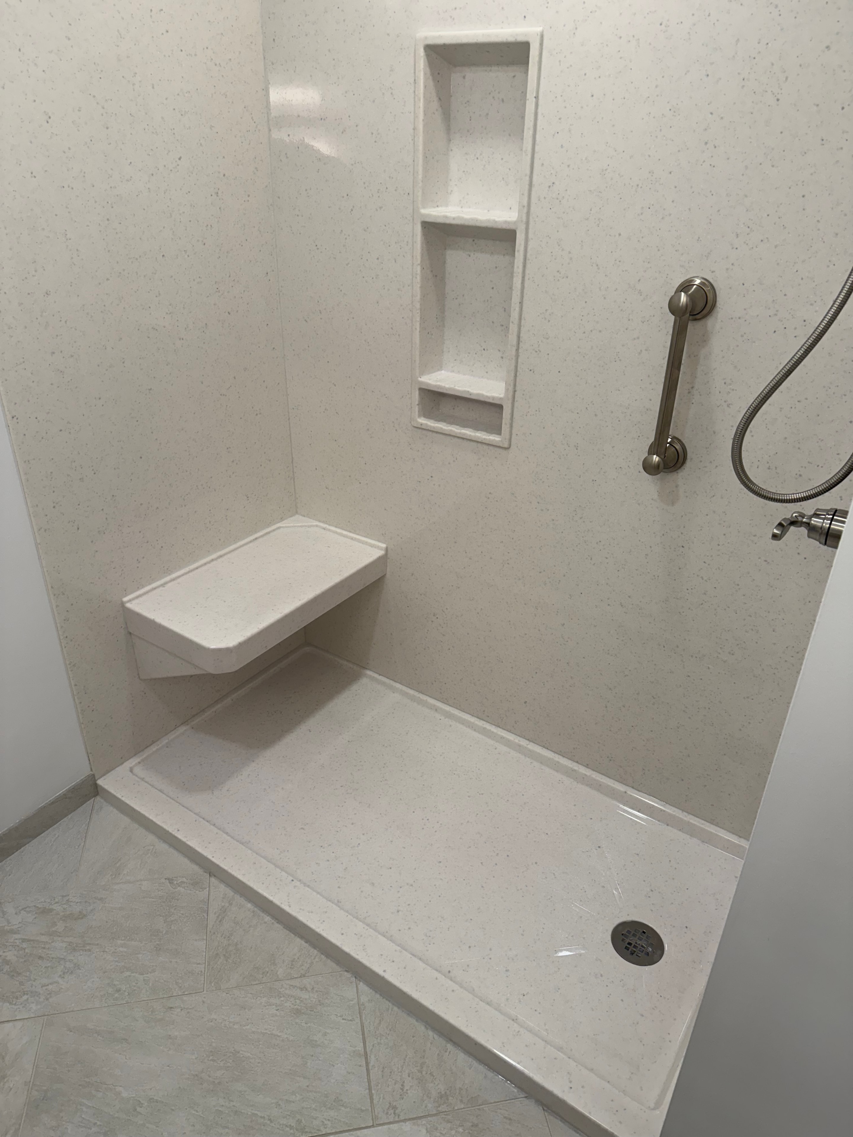 Clifton Park bathroom remodel - onyx shower surround with built-in bench seat, recessed shampoo holder, and hand shower
