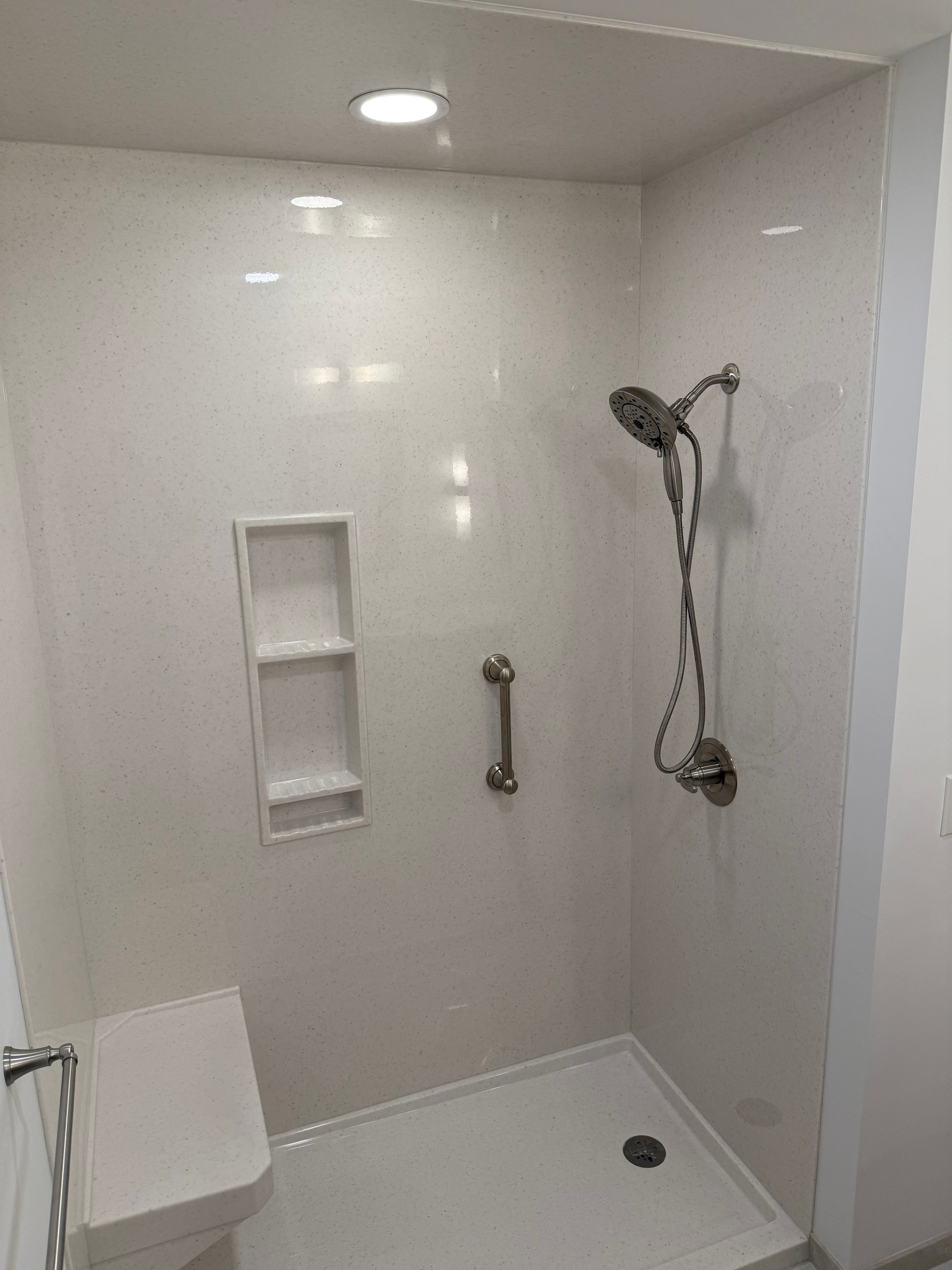 Clifton Park bathroom remodel - shower interior view with onyx surround, dual shower heads, and built-in niche
