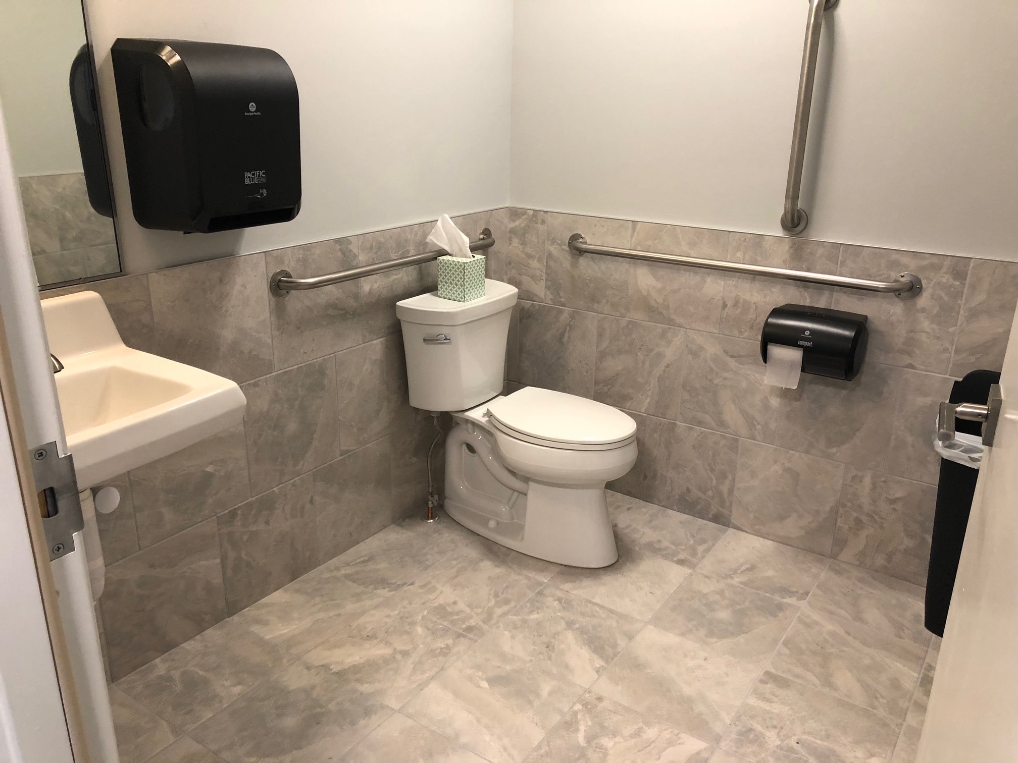 Commercial bathroom remodel - ADA compliant with large-format marble-look tile and stainless grab bars