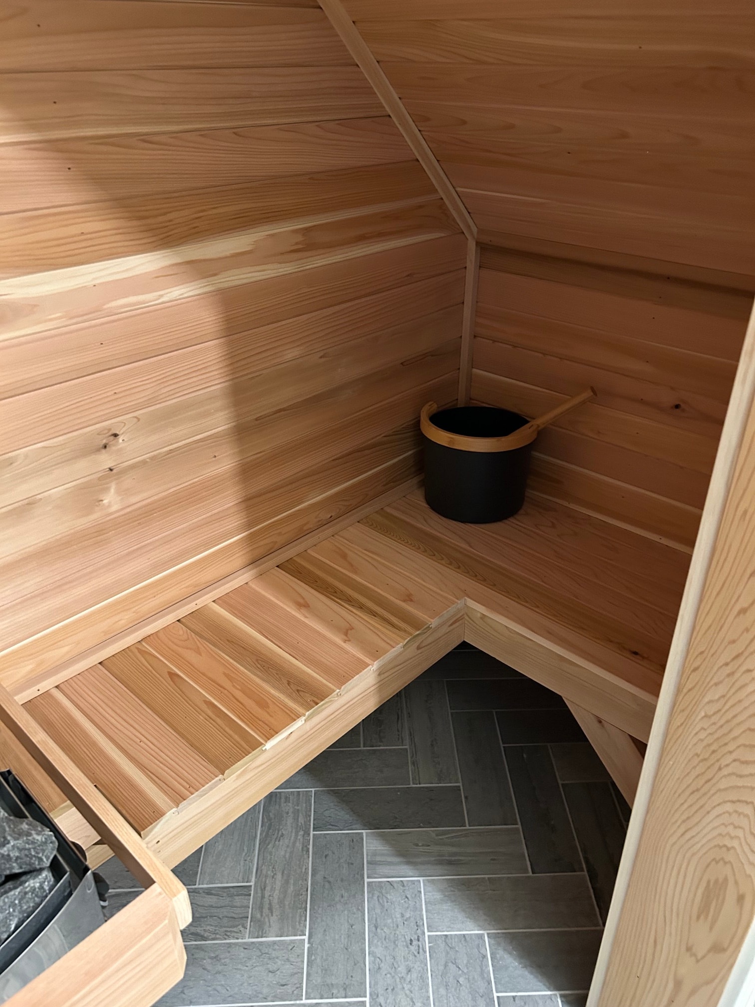 Niskayuna sauna and spa bathroom - cedar barrel sauna interior with bucket and sauna heater