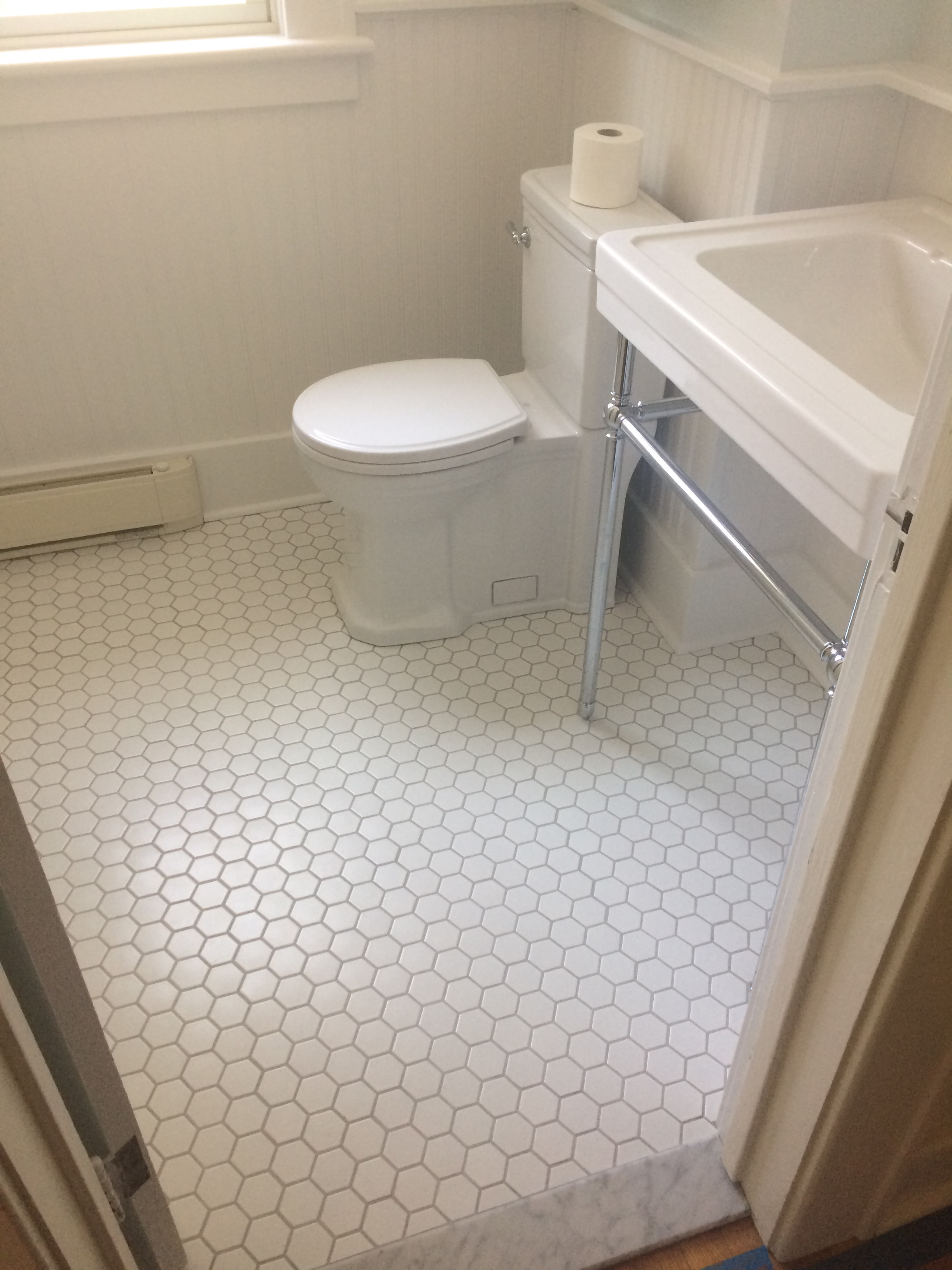 Niskayuna 2 bathroom remodel - white hexagonal floor tile with toilet and chrome shower rod