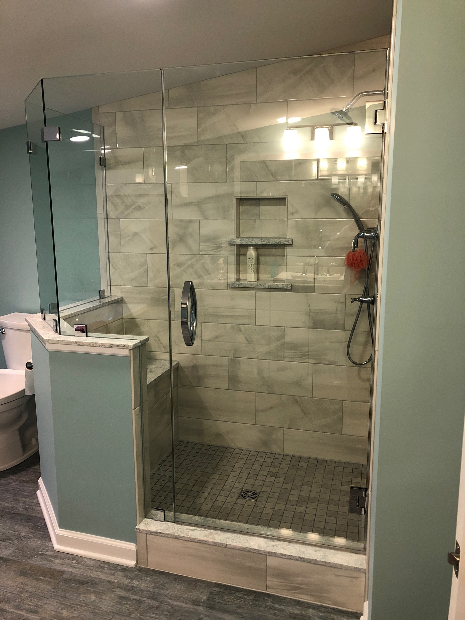 Saratoga Lake bathroom remodel - shower niche detail with chrome rain head and marble-look tile