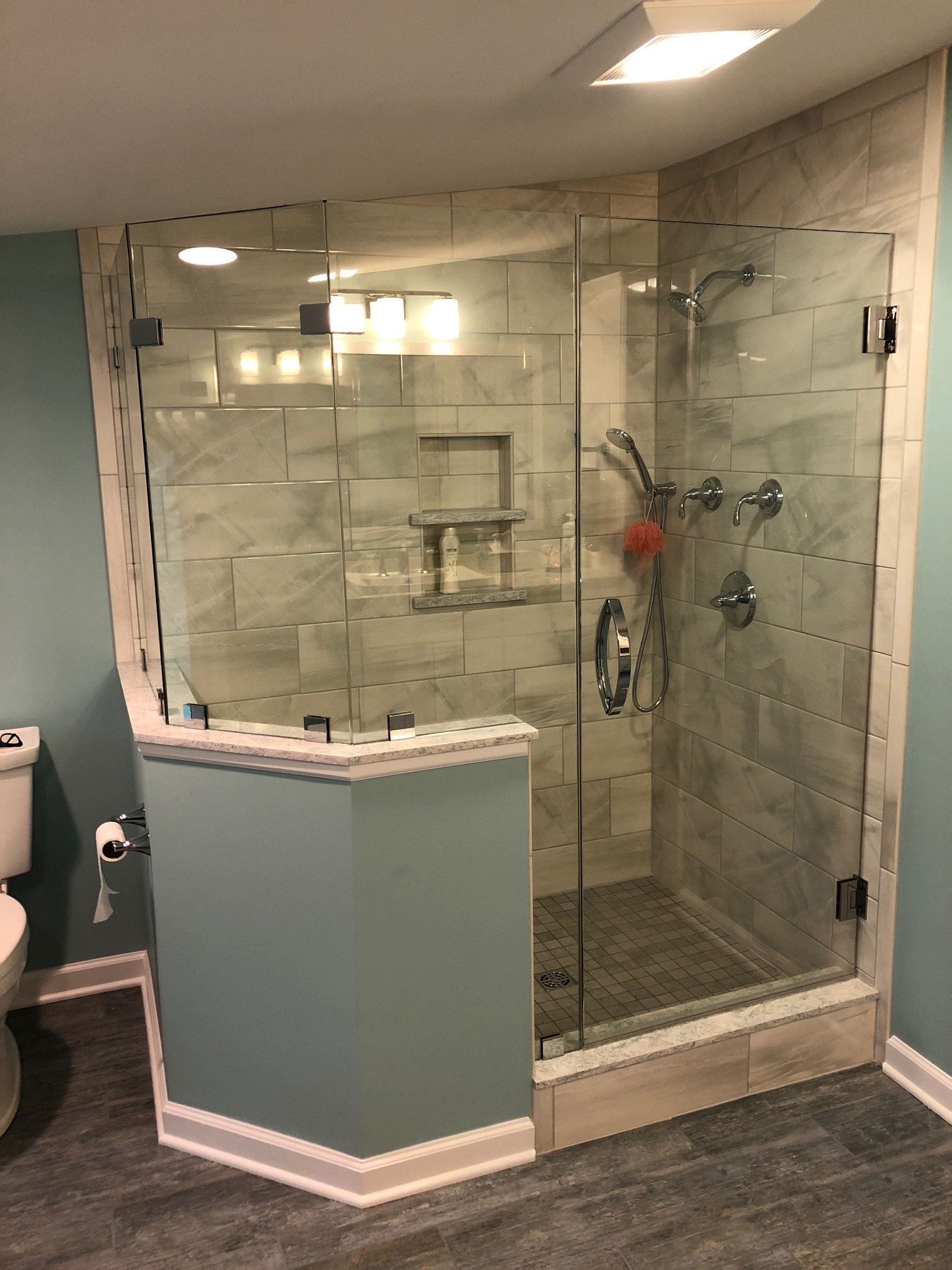 Saratoga Lake bathroom remodel - wide view of frameless glass shower with bench seat and wood-look floor tile