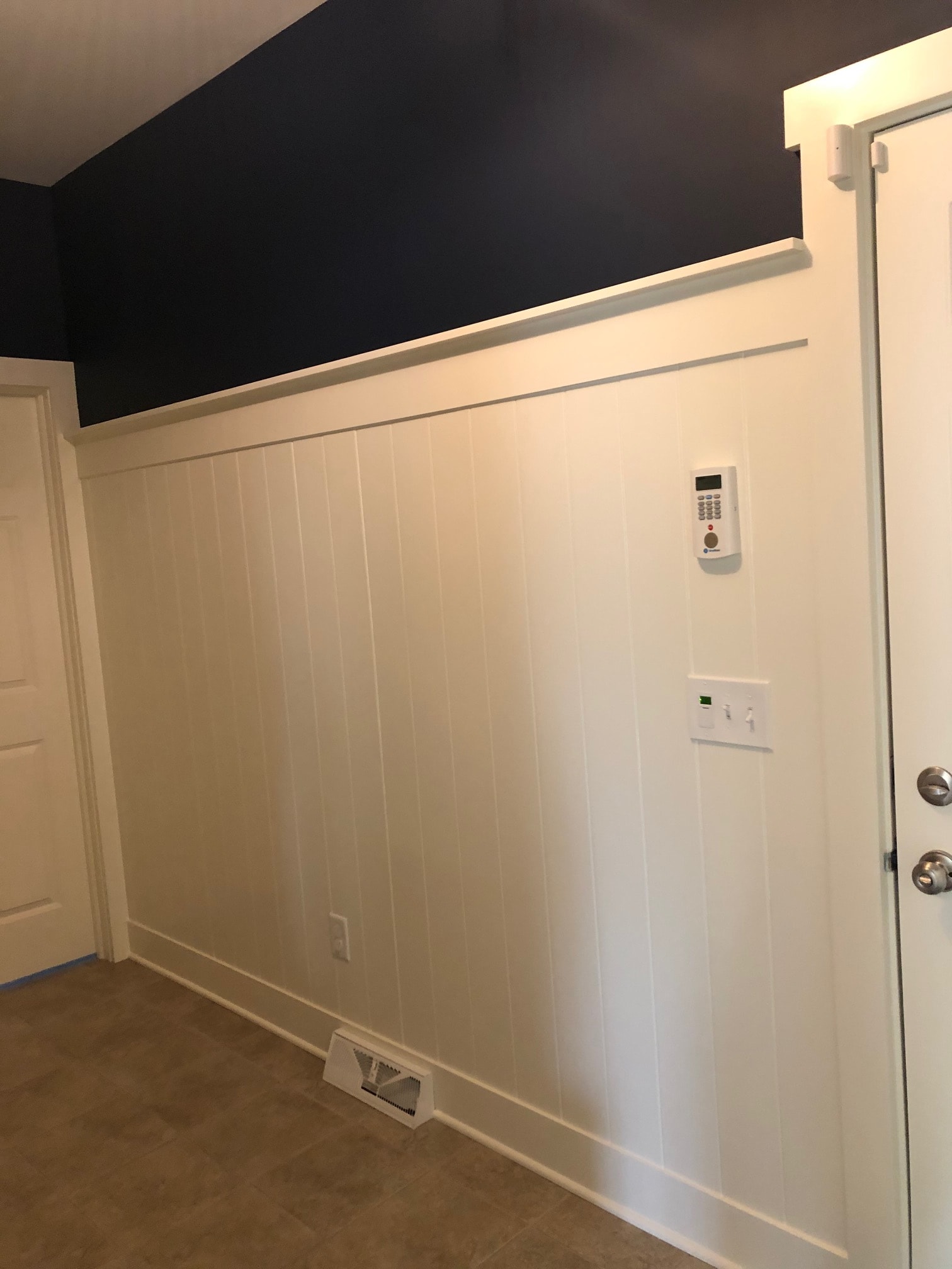 Altamont mudroom shiplap wall detail with raised panel cabinet door and navy accent wall