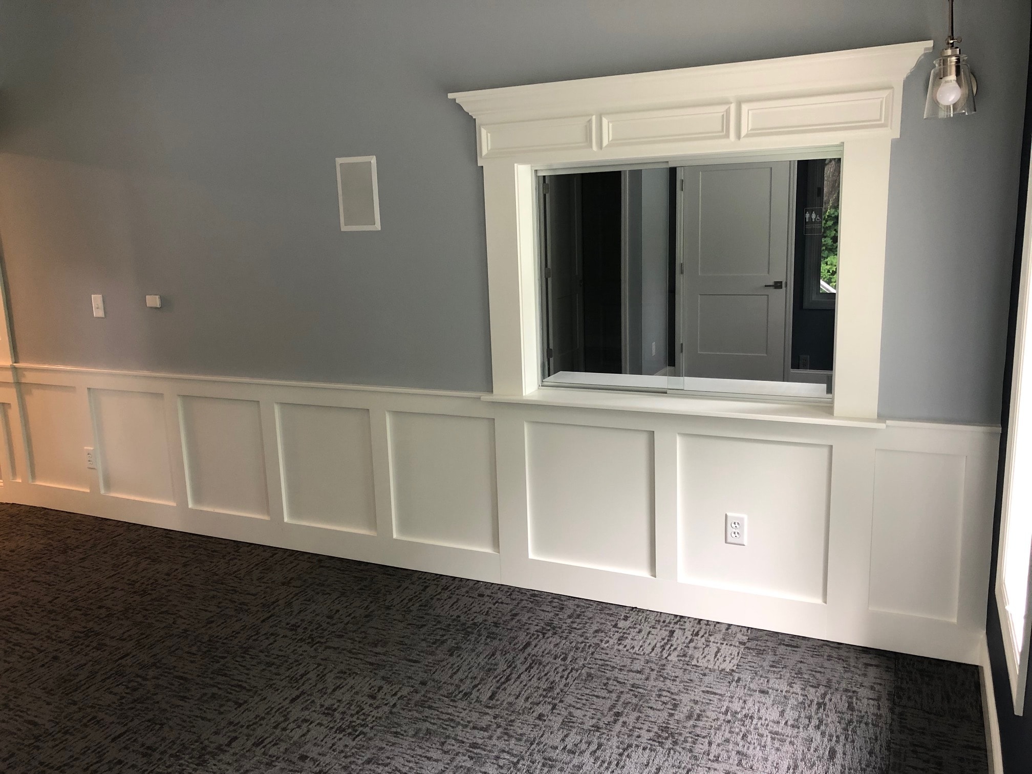 Colonie office wainscoting and service window detail with custom crown molding surround and board and batten panels