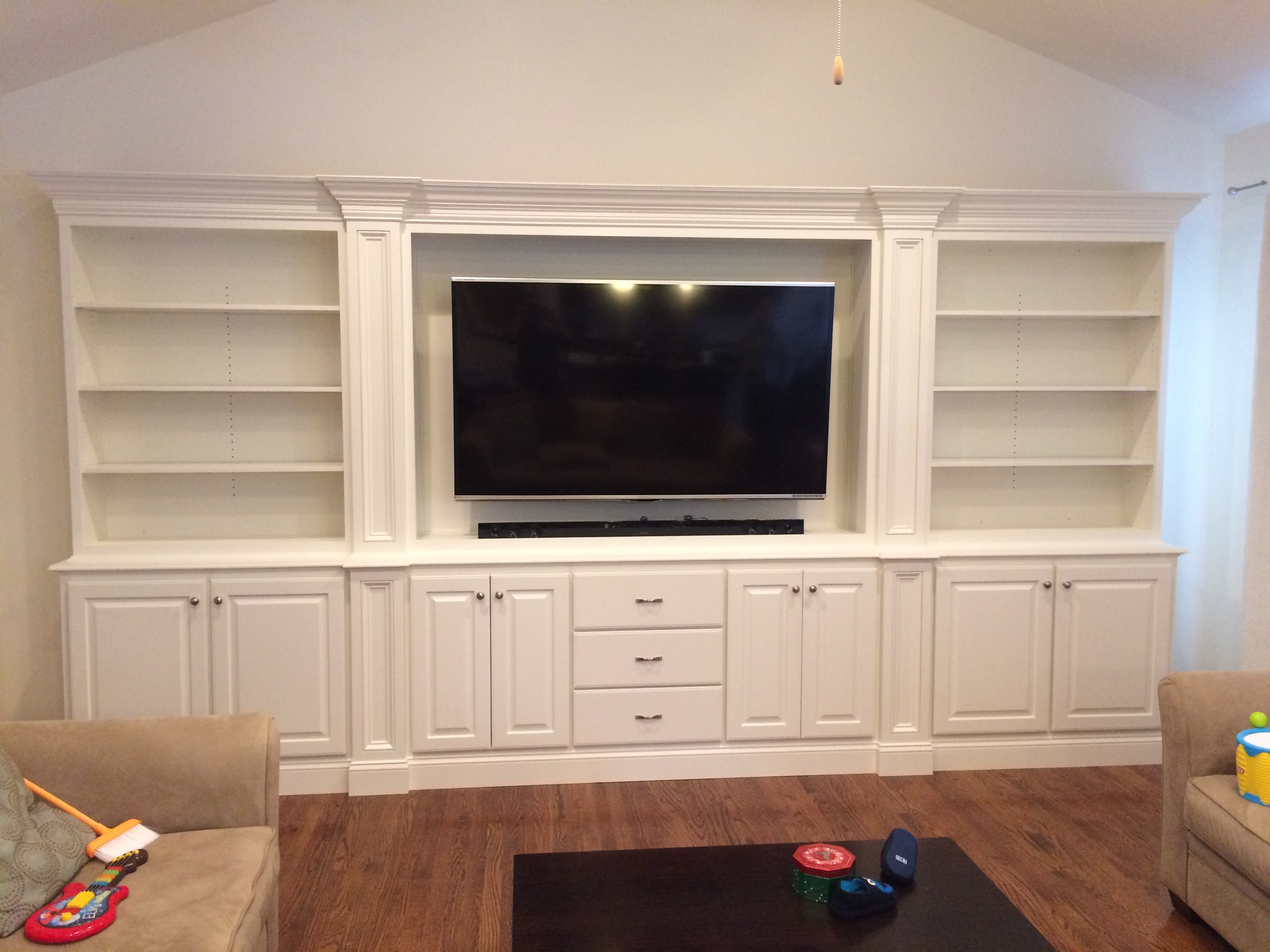 Guilderland entertainment center - wide view of full built-in wall unit with vaulted ceiling, open shelving, TV niche, and lower cabinets