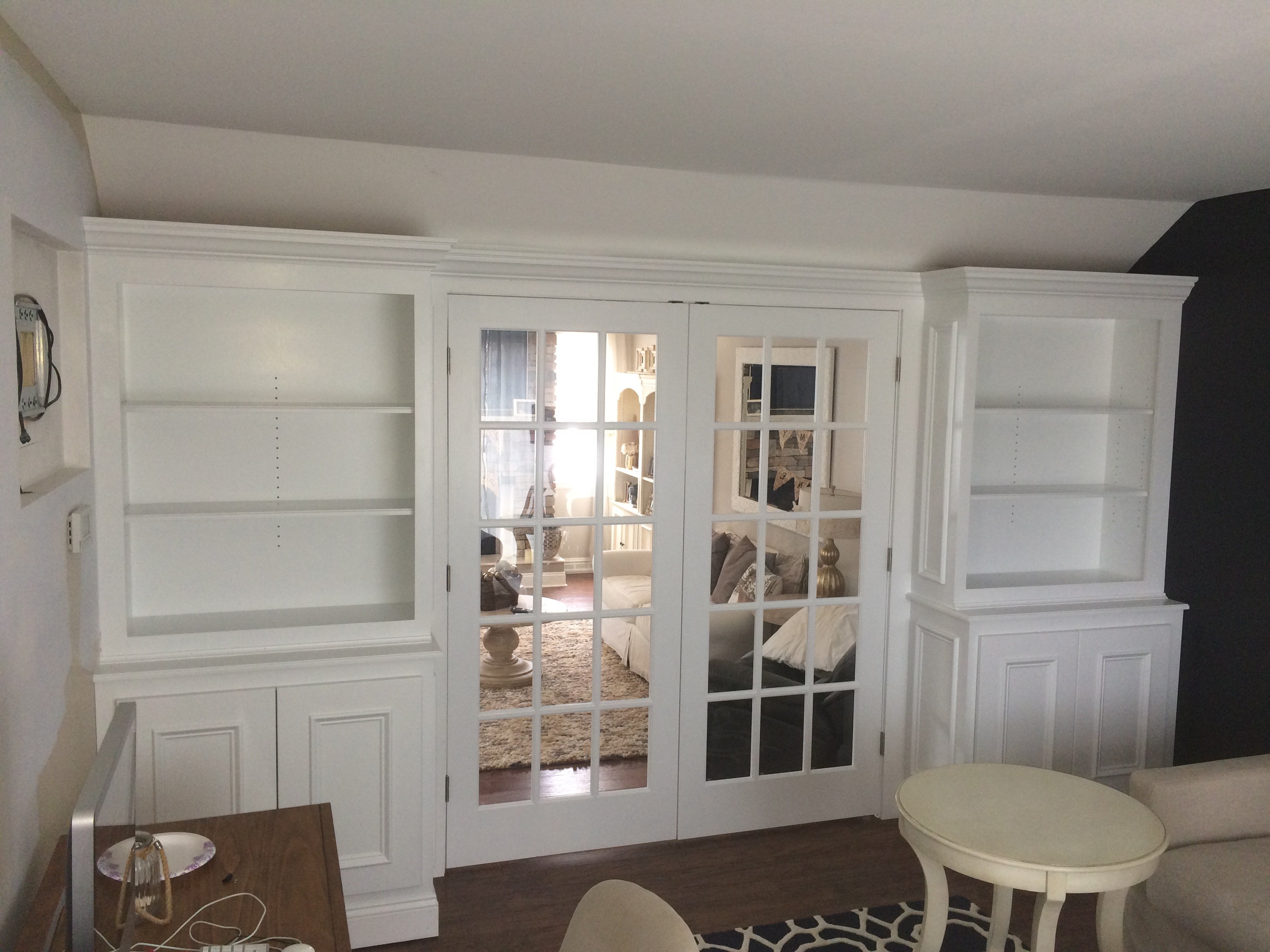 Loudonville built-in bookcases flanking French doors with raised panel lower cabinets and crown molding
