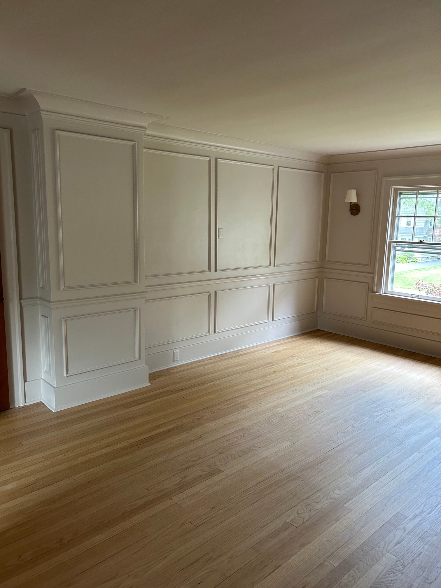 Niskayuna master bedroom raised panel wainscoting wall with window and coffered ceiling panels above