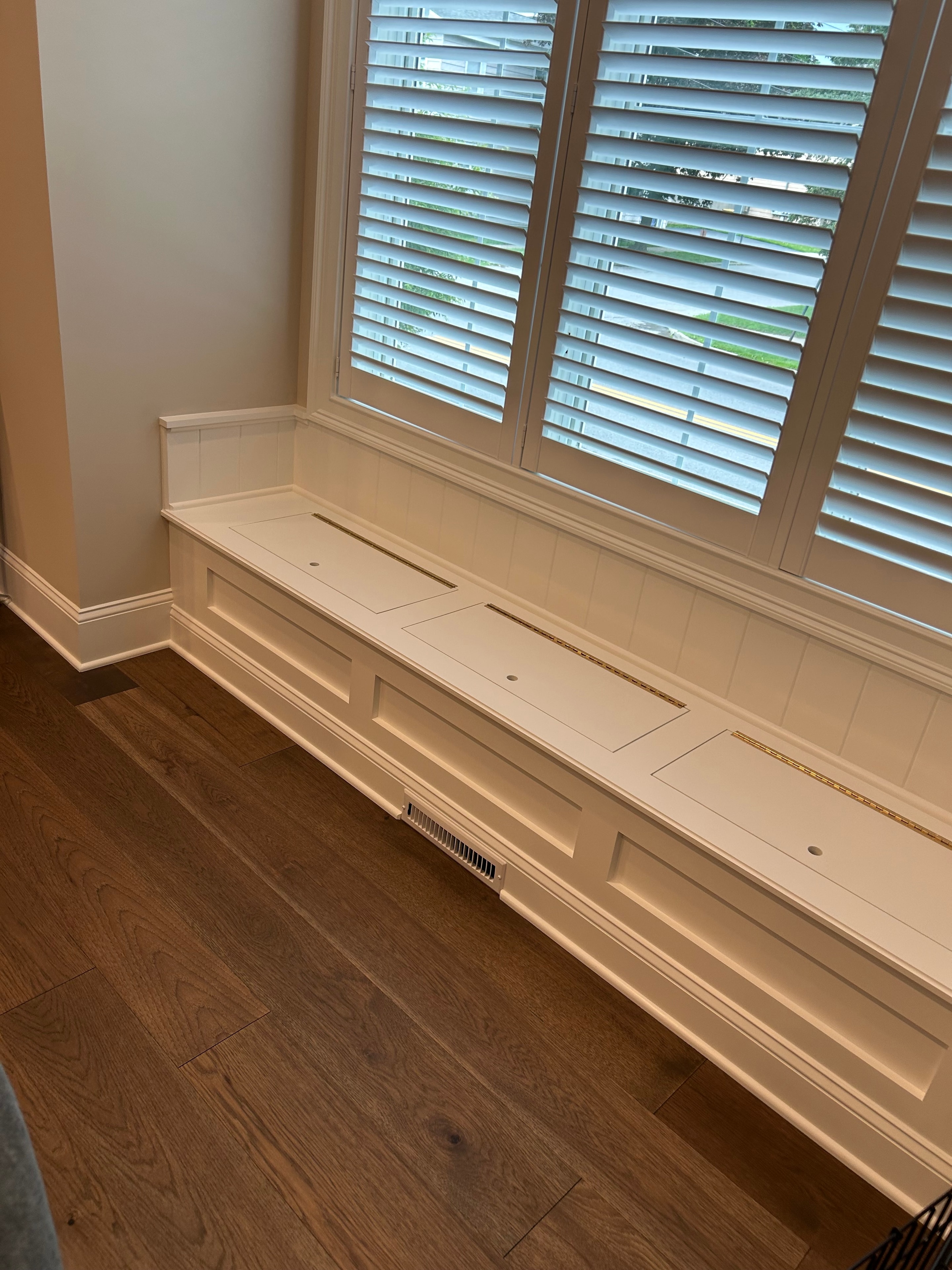 Saratoga Springs window seat full view with raised panel bench, shiplap ceiling detail, crown molding, and oak hardwood floor