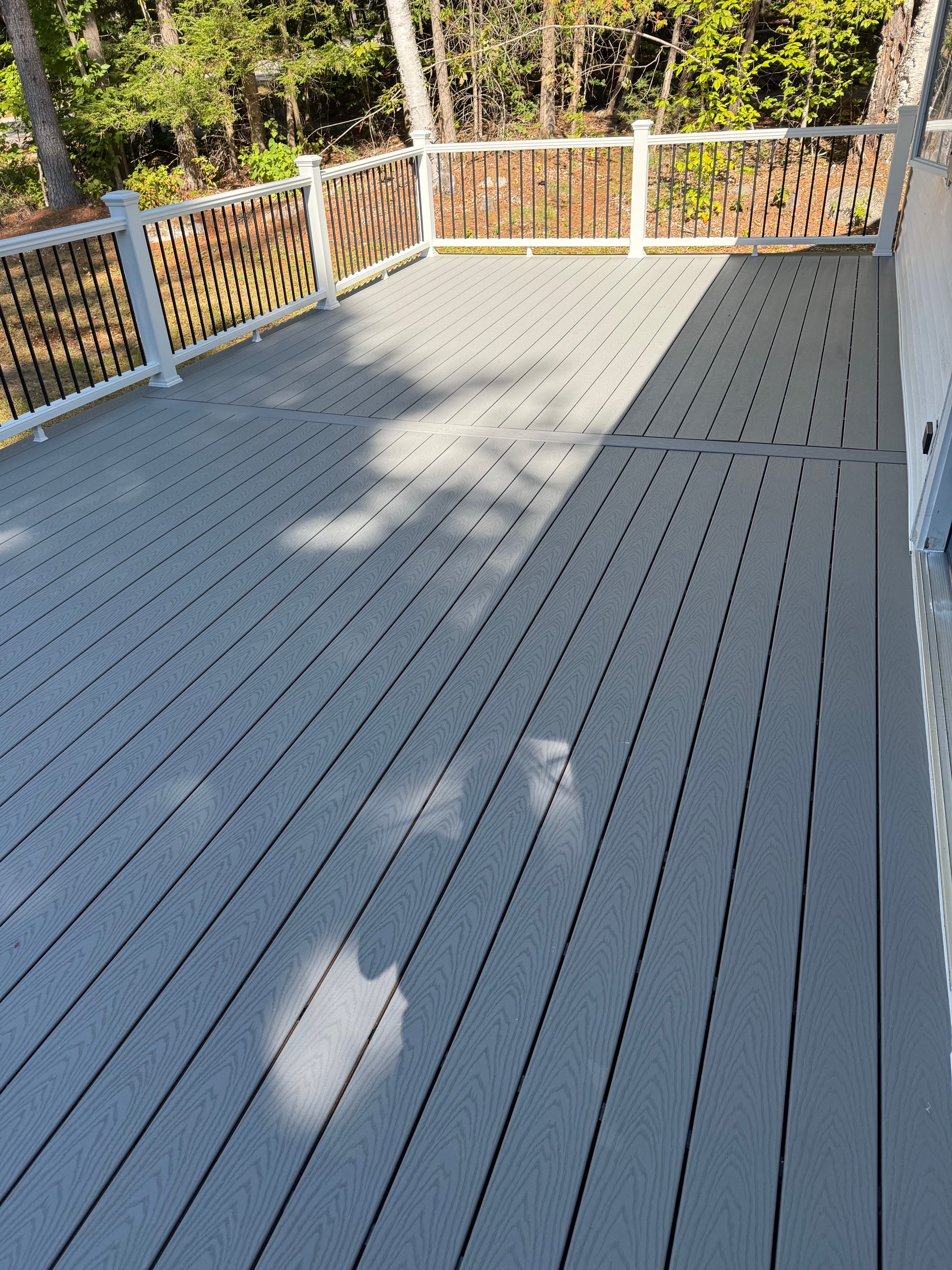 Schroon Lake deck overhead composite decking surface detail with white railing and stair landing